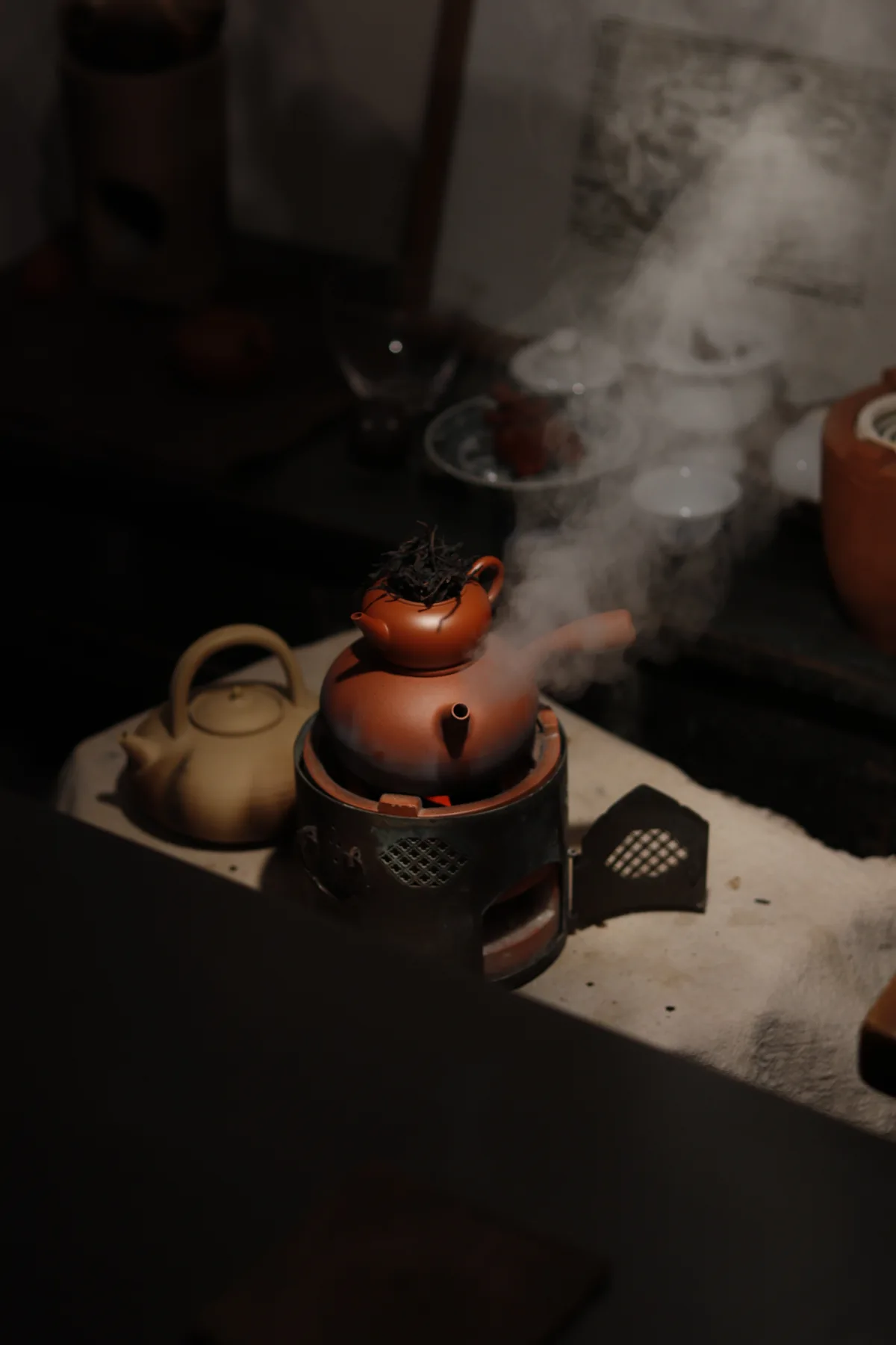 Steam rising around a teapot and kettle in Yujian Cai’s studio