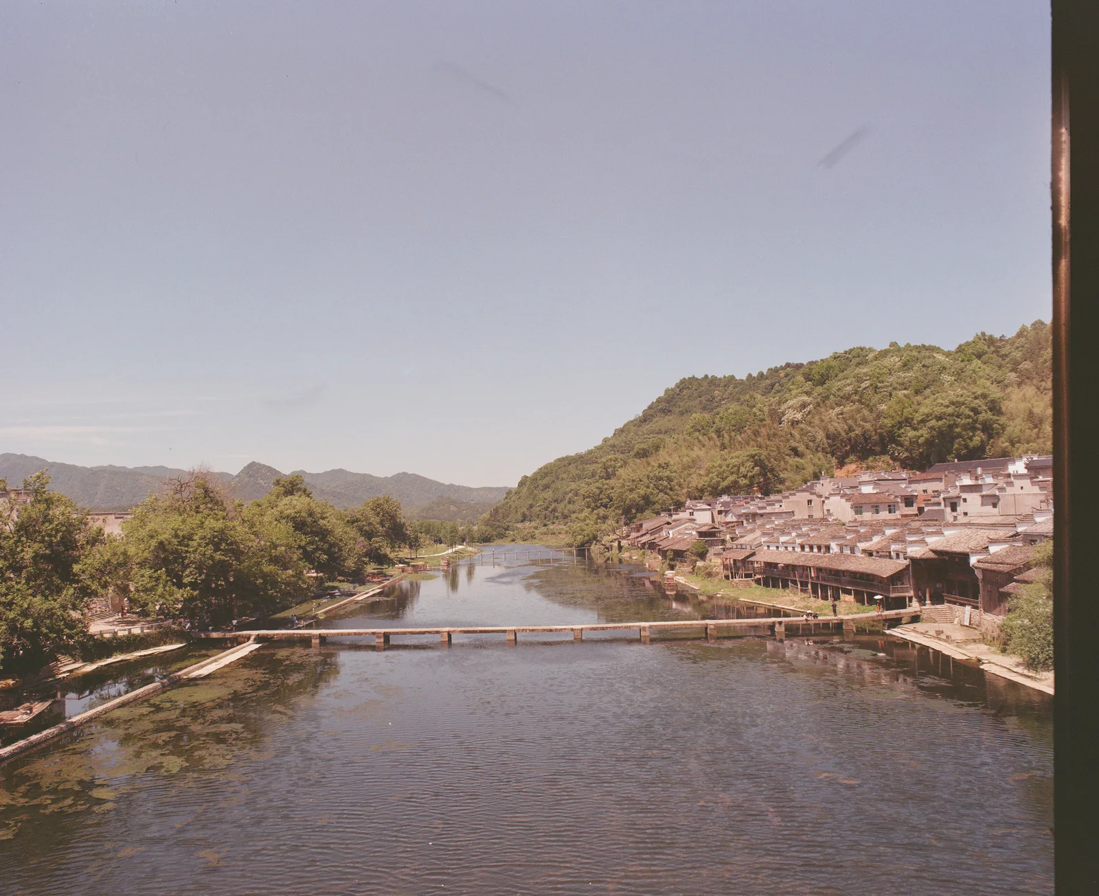 A river and stone crossing beside traditional village houses in Fuliang