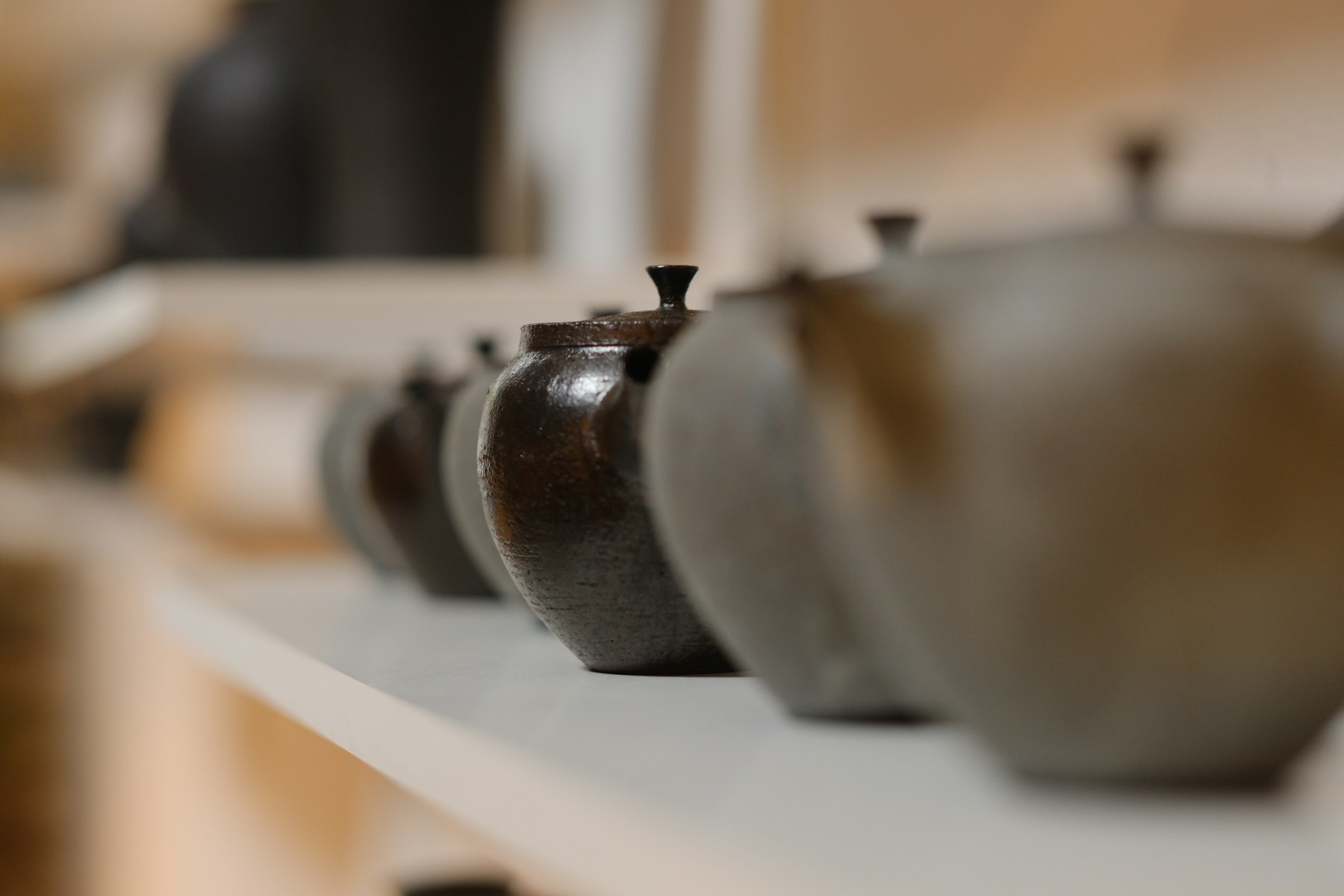 Handmade ceramic vessels displayed on a shelf