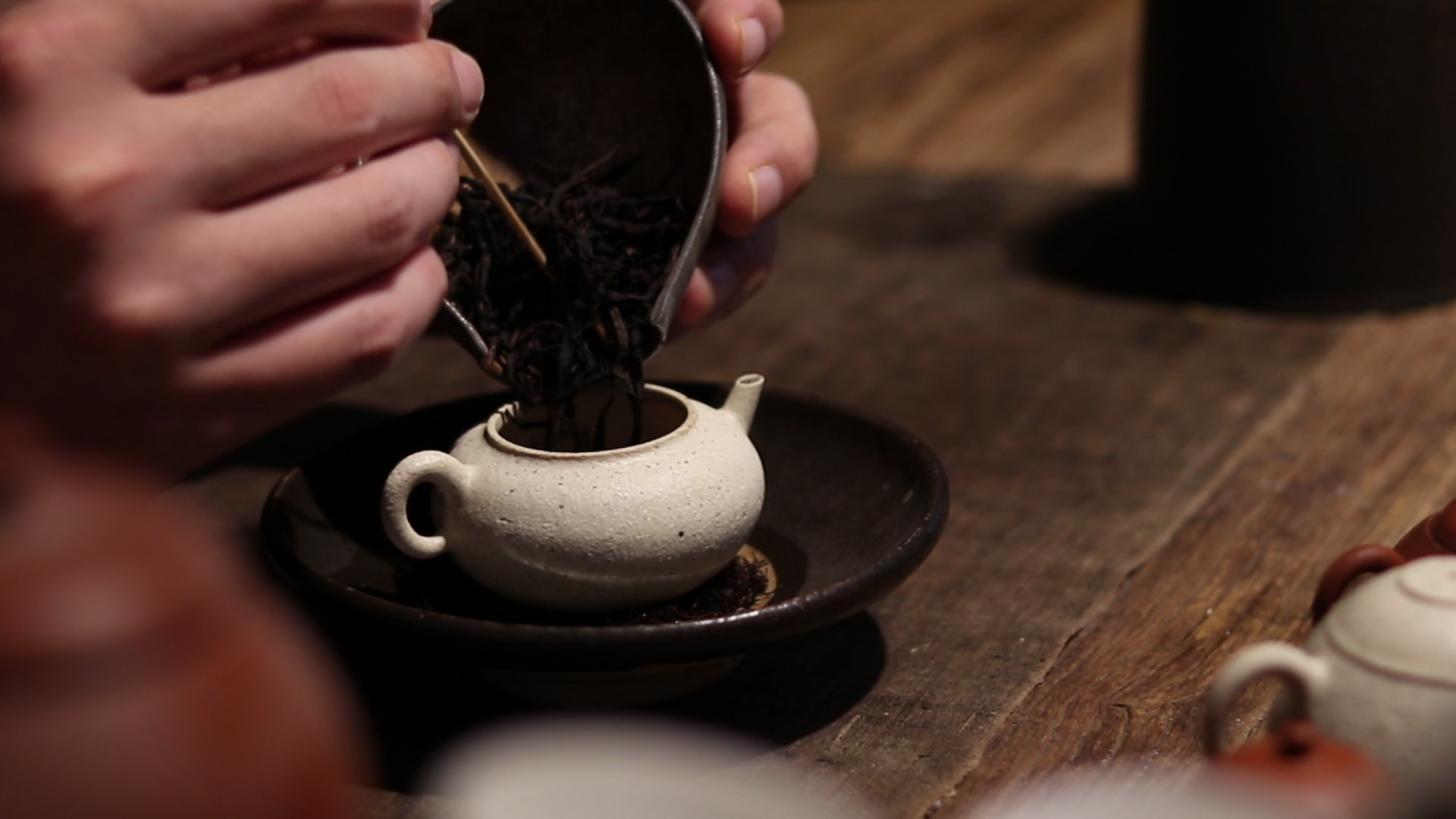 Tea leaves being added to a handmade teapot at Zheng Bixin’s tea table