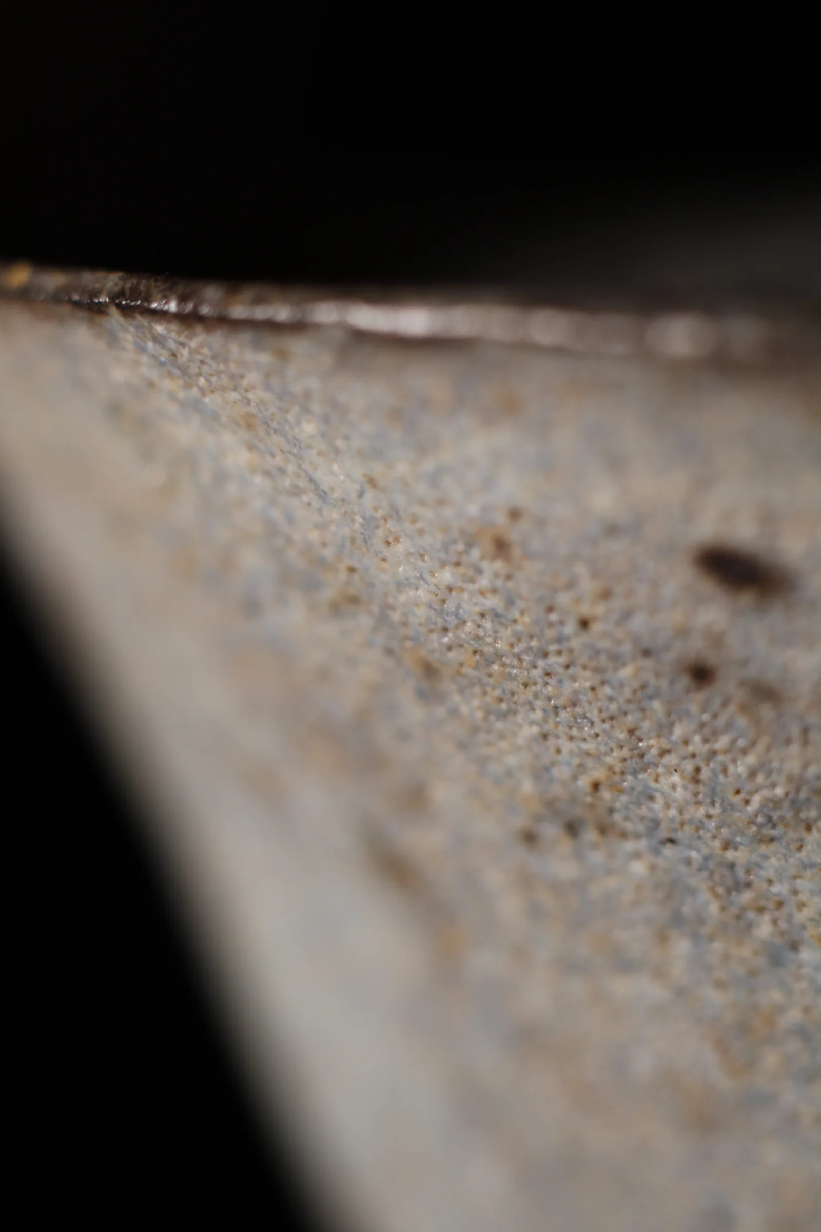 Close view of the unglazed black stoneware rim
