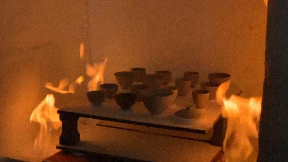 Ceramic vessels surrounded by flames during firing