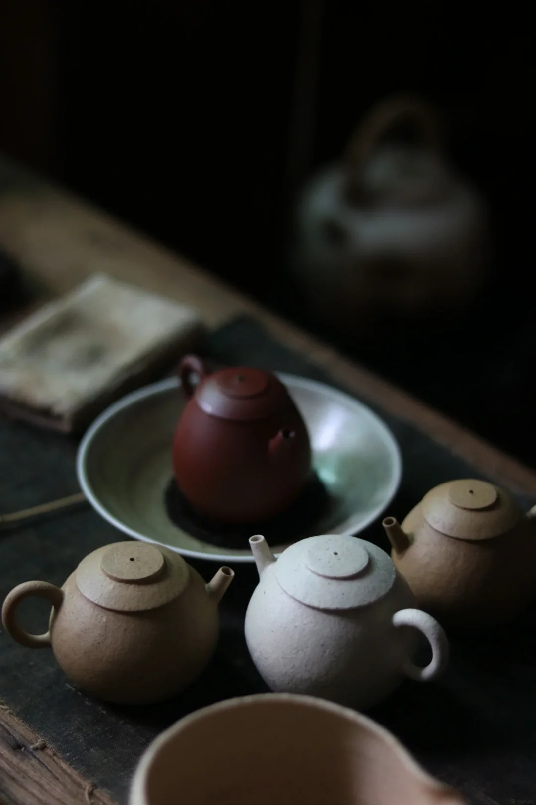 A group of teapots with varied clay tones and textures